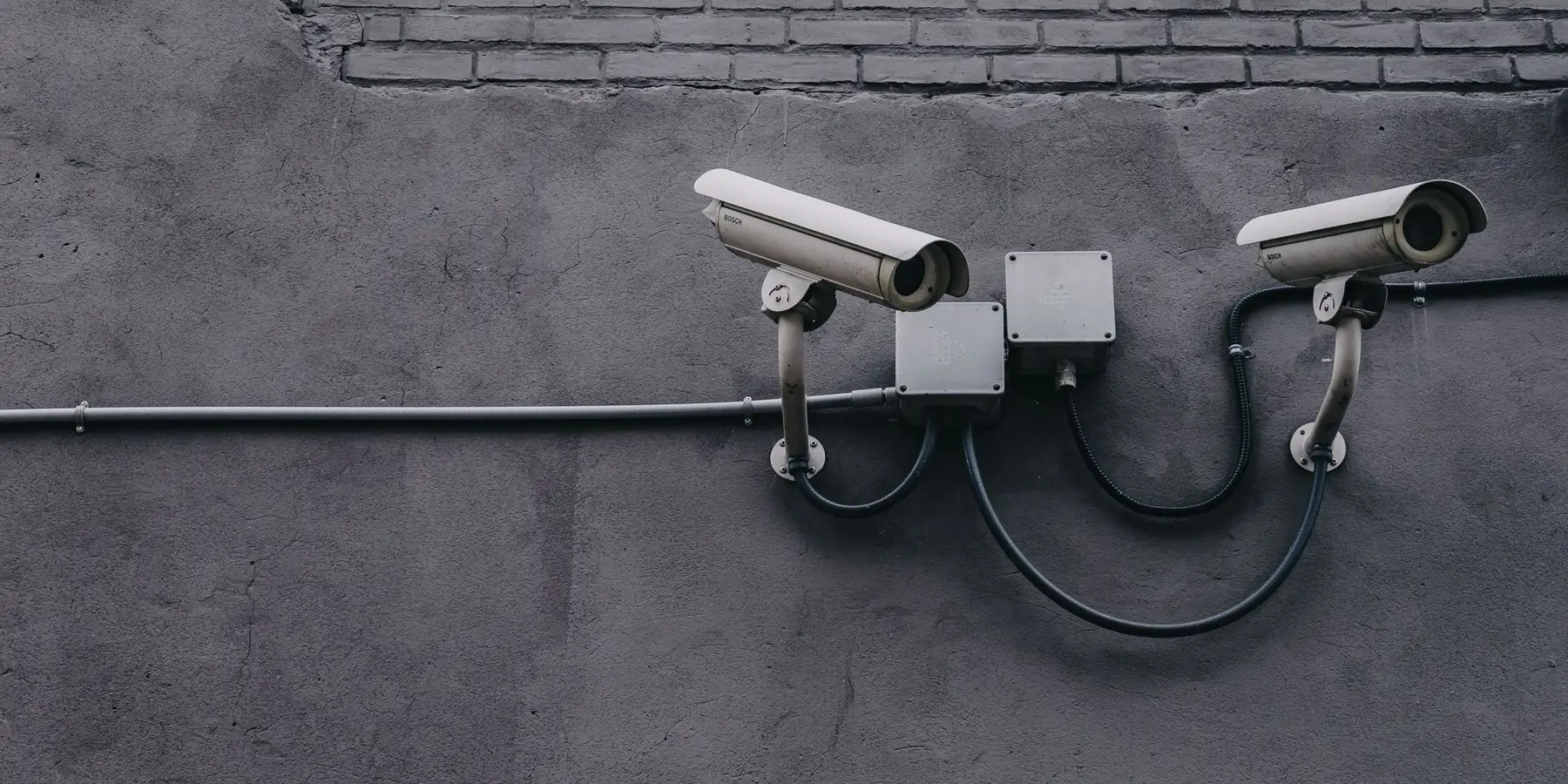 Dos cámaras de seguridad instaladas en una pared, con su caño y su caja de paso